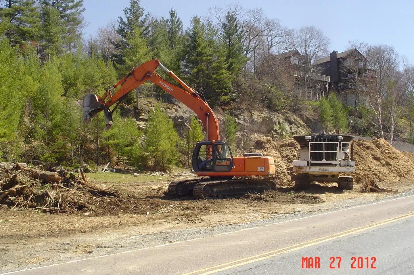 Tree crew clearing debris with a stump grinder on a job site